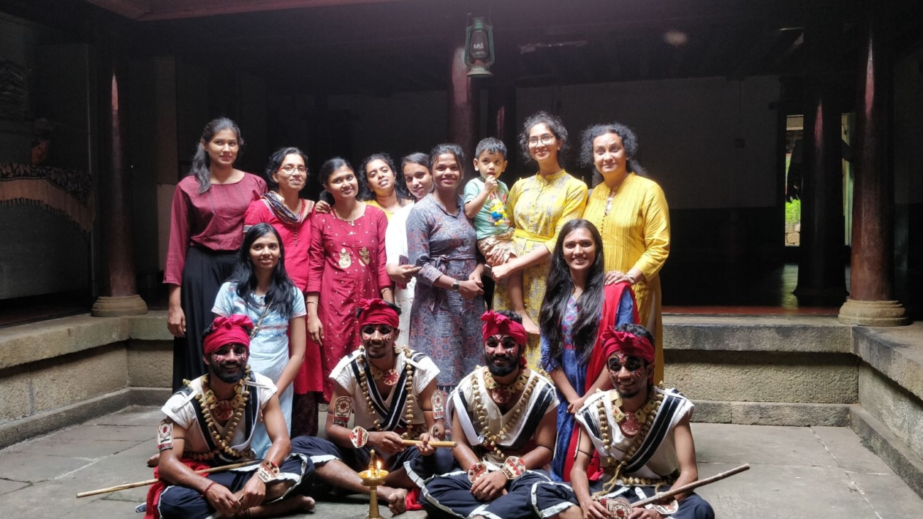 Travelers posing for photo along with Kanyarkali performers of Palakkad, Kerala. Cultural tour organized by Moksha Stories.