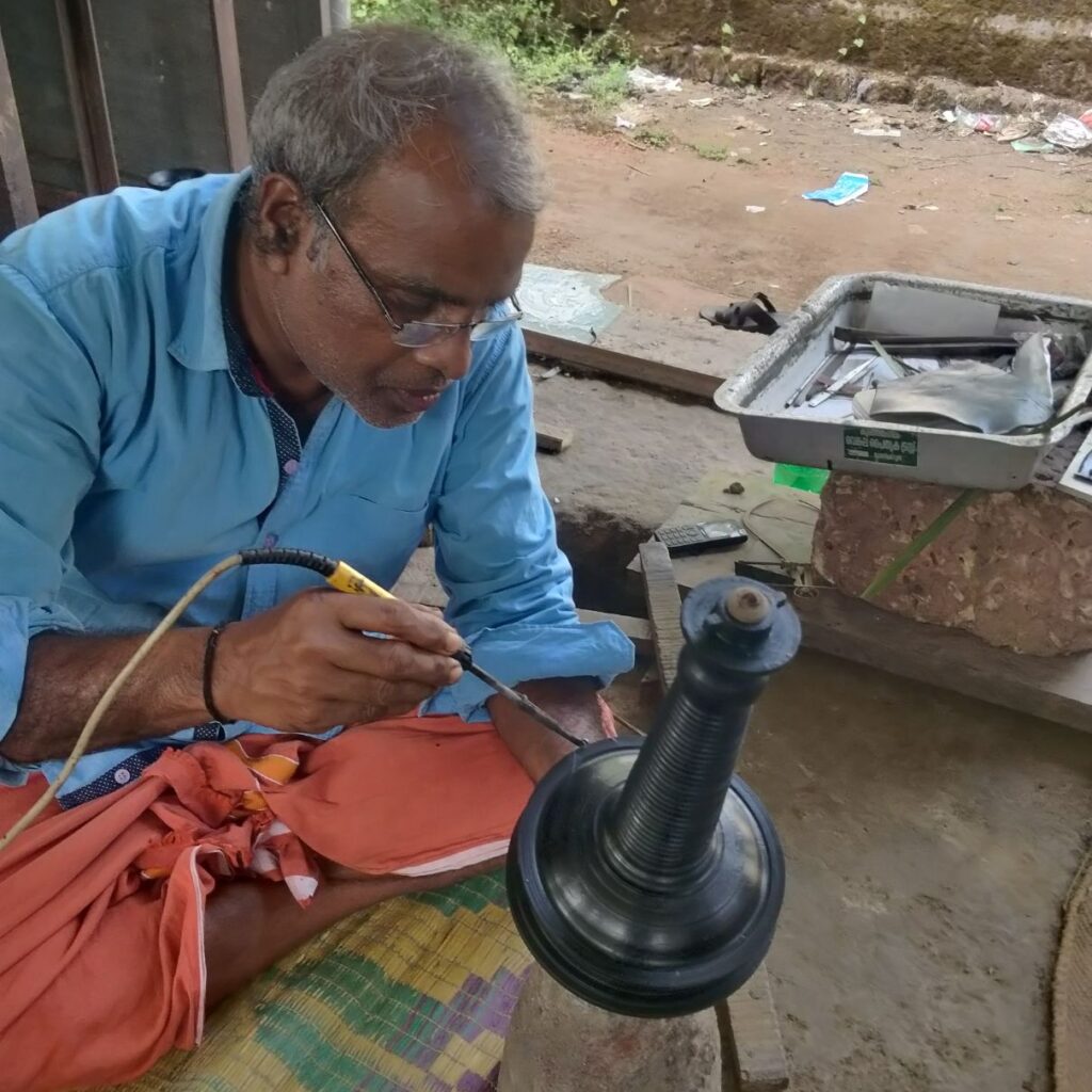 An artist preparing mold for traditional Kerala lamp in bell metal unit of Kannur, Kerala