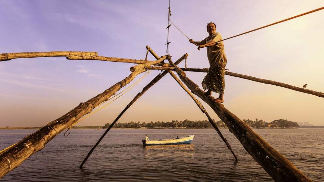 Fisherman operating Chinese fishing net in Muziris