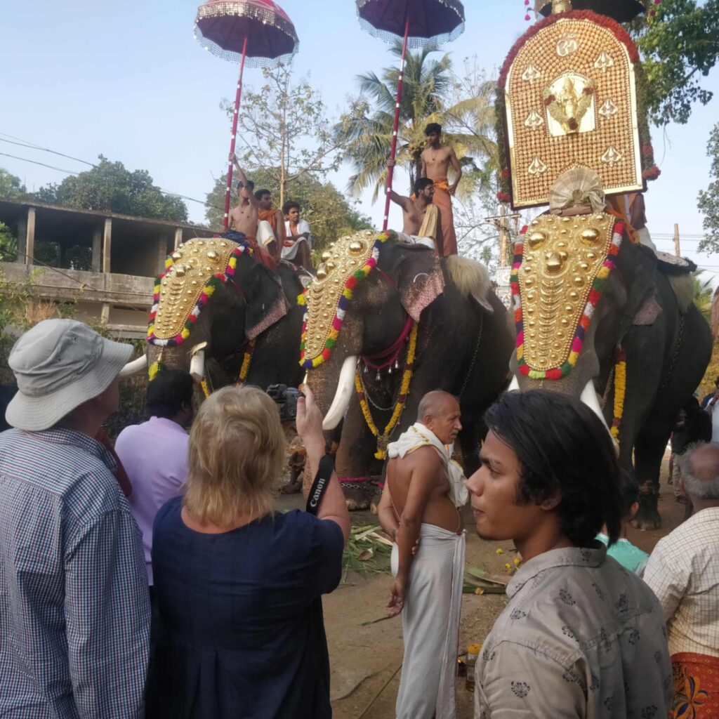 A traveler taking a picture during a festival in Kerala