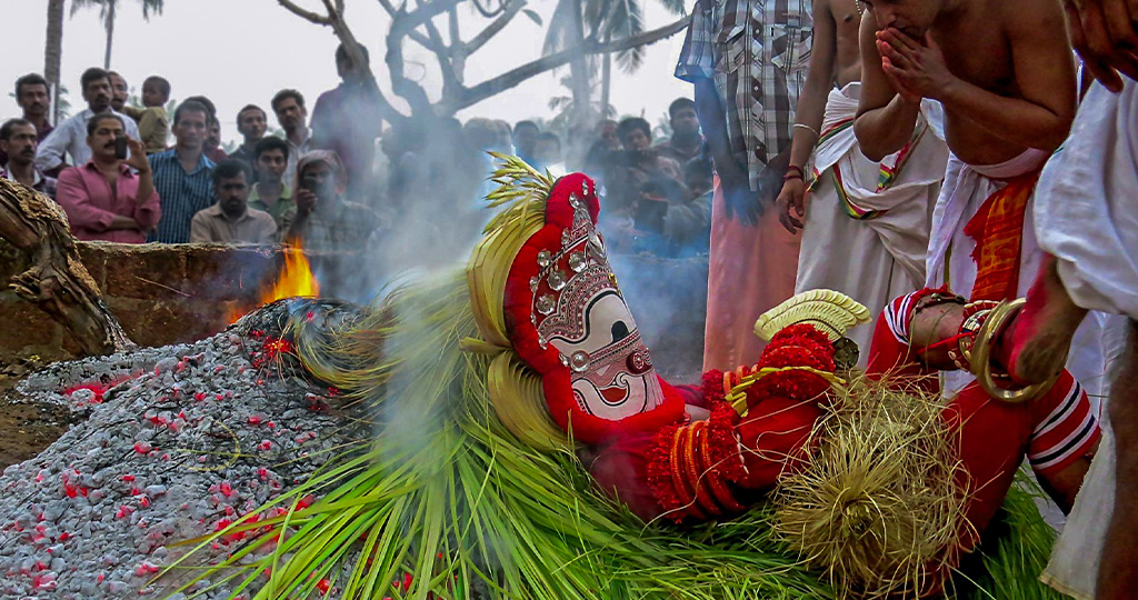 Pottan Theyyam resting on top of pyre.