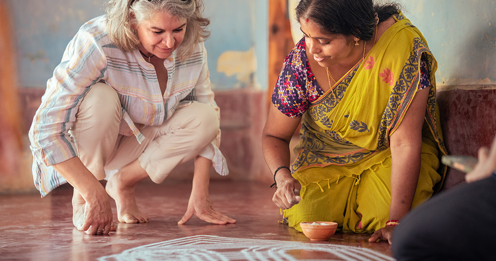 A traveler involved in Kolam drawing. An essence of travel design by Moksha Stories