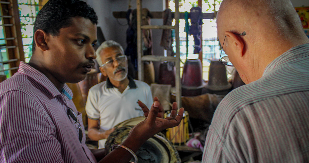 A traveler understanding about various percussion instruments of Kerala.