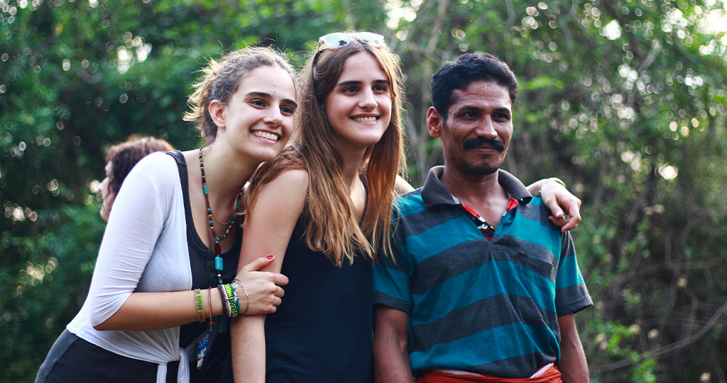 Travellers posing with a toddy tapper in Kerala- Moksha Stories.
